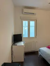 Habitación Doble Confort con dos camas individuales separadas y lámparas de pared encendidas